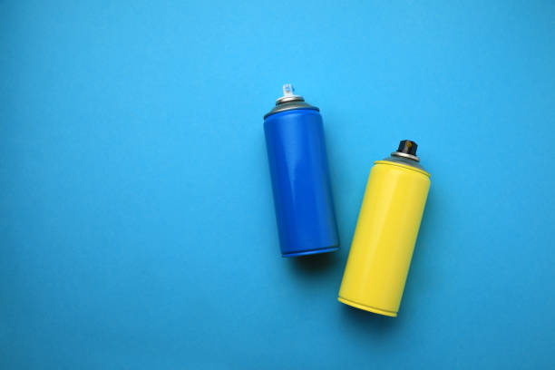 istock Cans of different graffiti spray paints on light blue background, flat lay. Space for text 1391590728