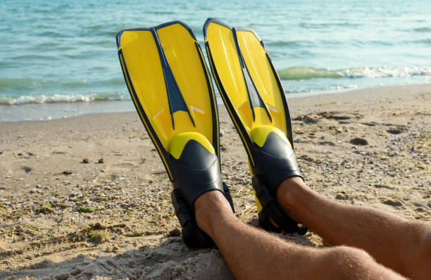 istock Man in flippers near sea on beach, closeup 1391593849