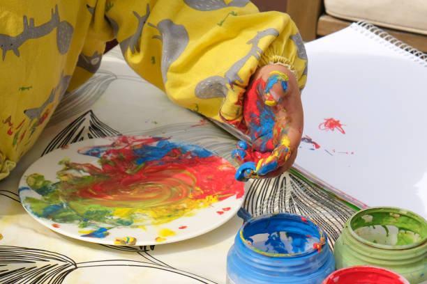 istock Early childhood development activity: finger painting outside on a sunny day 1391593857