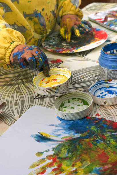 istock Early childhood development activity: finger painting outside on a sunny day 1391593883