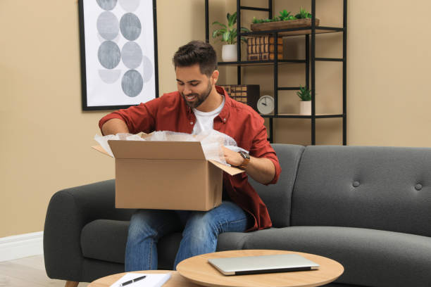 istock Man unpacking parcel at home. Online shopping 1391594594