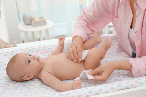 istock Mother changing her baby's diaper on table at home 1391594846