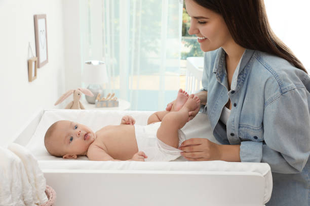 istock Mother changing her baby's diaper on table at home 1391594849