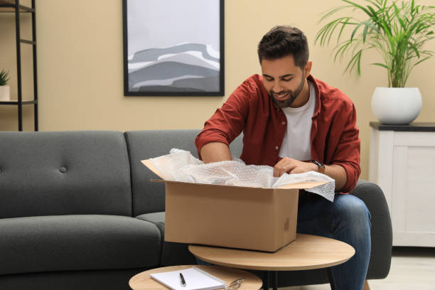 istock Man unpacking parcel at home. Online shopping 1391594876