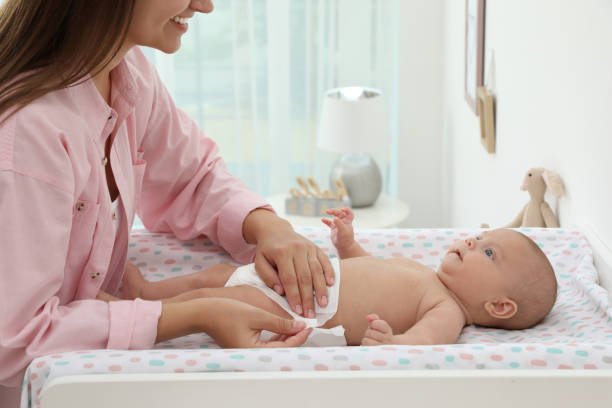 istock Mother changing her baby's diaper on table at home 1391595132