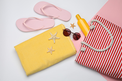 Stylish bag and beach accessories on color background, flat lay