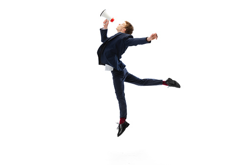 Studio shot of young male ballet dancer wearing business suit dancing isolated on white studio background. Business, start-up, art, work, caree, inspiration concept. Contemporary ballet dance. Copy space for ad