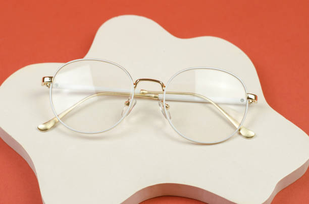 istock Stylish women's glasses in a white frame on a white plaster podium 1391596556