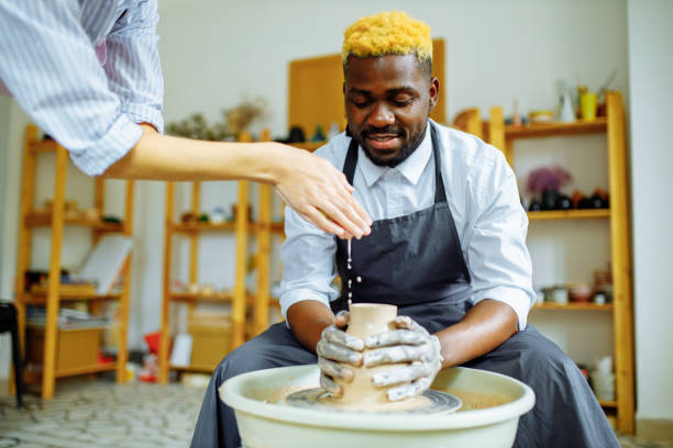 istock mixed race hands couple making vase in art studio 1391596586