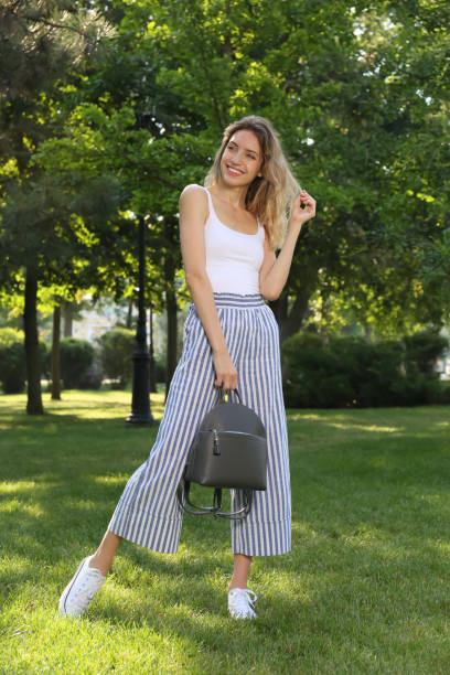 istock Young woman with stylish backpack in park 1391596623