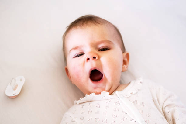 Adorable little baby girl is yawning on her bed before go to sleep. Adorable little baby girl is yawning on her bed before go to sleep. sleep issues in babies stock pictures, royalty-free photos & images