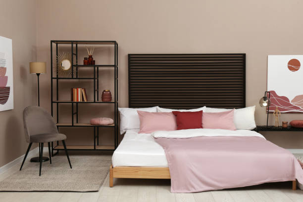 istock Large comfortable bed near beige wall in room. Interior design 1391596746