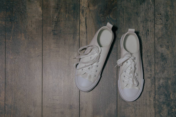istock White children's sneakers with glitter effect. On a textured background 1391597519