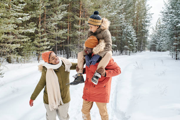 junge zeitgenössische familie von vater, mutter und sohn genießt wintertag im park - snow walking stock-fotos und bilder