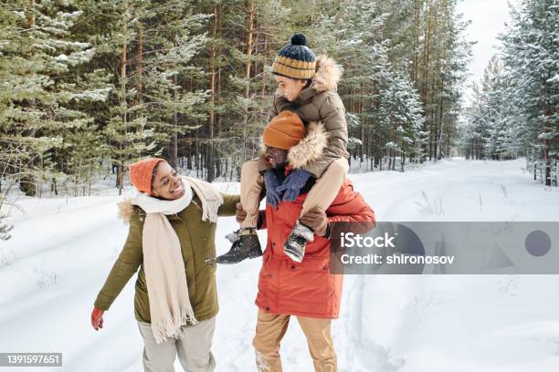 Young Contemporary Family Of Father Mother And Son Enjoying Winter Day In Park Stock Photo - Download Image Now