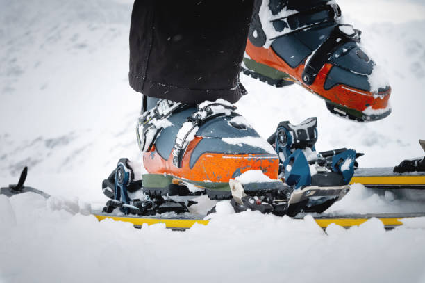 крупный план лыжных ботинок для фрирайда на снегу. концепция скитура. использованы поношенные ботинки на лыжнике-мужчине на фоне ледника в  - skitour стоковые фото и изображения