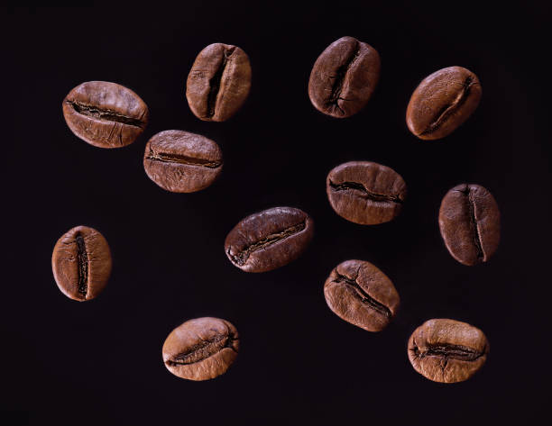 primer plano de los granos de café sobre fondo oscuro. - bean macro brown roasted fotografías e imágenes de stock
