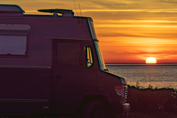 istock Camper vehicle on beach at sunrise 1391600854