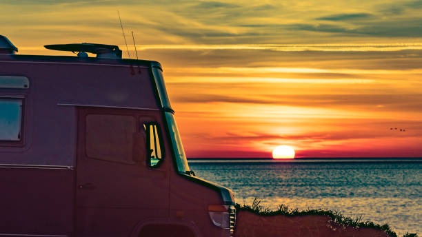 istock Camper vehicle on beach at sunrise 1391600949