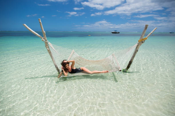 istock Woman in hammock on tropical beach at island 1391601325