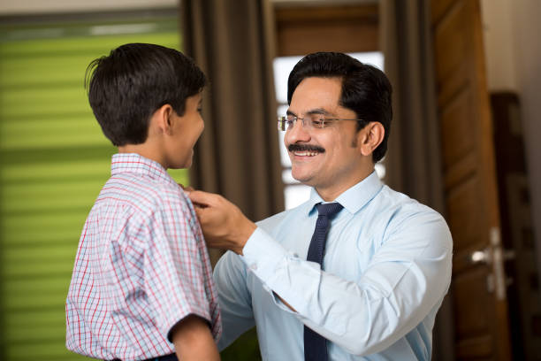 istock Happy boy adjusting necktie of his father while getting ready for office and school at home 1391608749