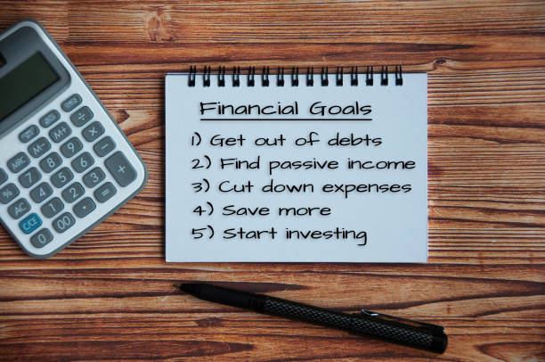istock Financial goals text on notepad with calculator and pen on a wooden table. 1391612915