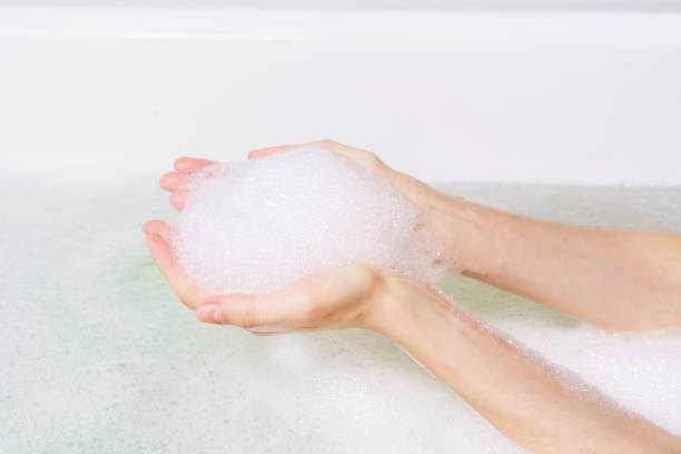 istock Female hands holding bubble foam in a bathtub 1391616265