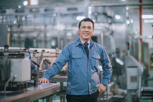Asian Malay mature man factory manager looking at camera smiling