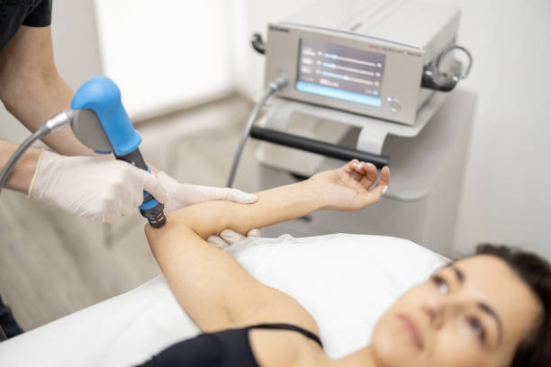 Doctor applies shock wave therapy on women's knee