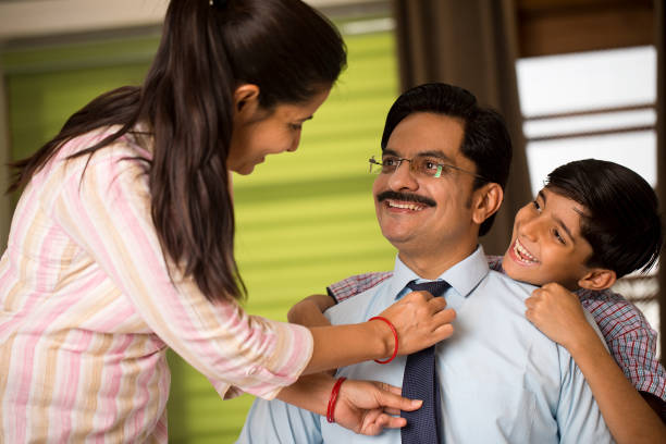 istock Woman adjusting necktie of her husband with son while getting ready for office and school 1391628802