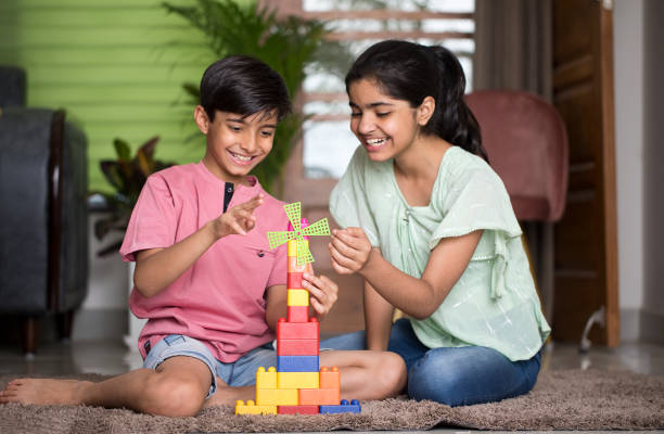 Happy boy and girl playing with toy blocks
