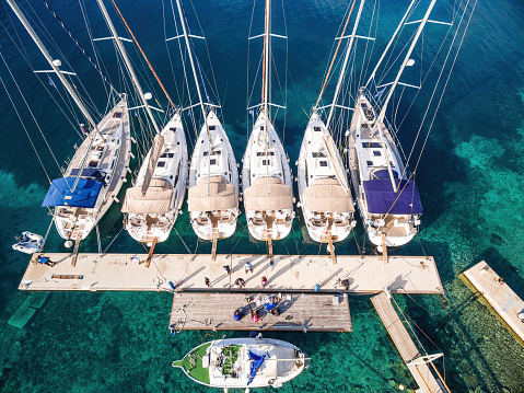 Moored sailboats at beautiful island Kornat, the main island from Kornati region islands, Dalmatia, Croatia, Europe. High angle view from drone.