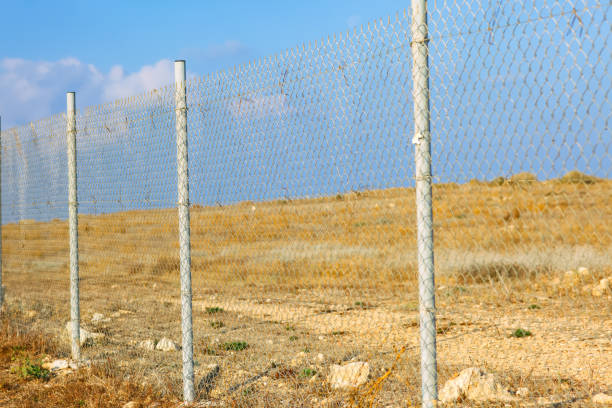 istock Chain link fence with a field behind it 1391637445