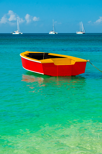 A brightly coloured wooden fishing boat in the turquoise waters of theCaribbean Sea.