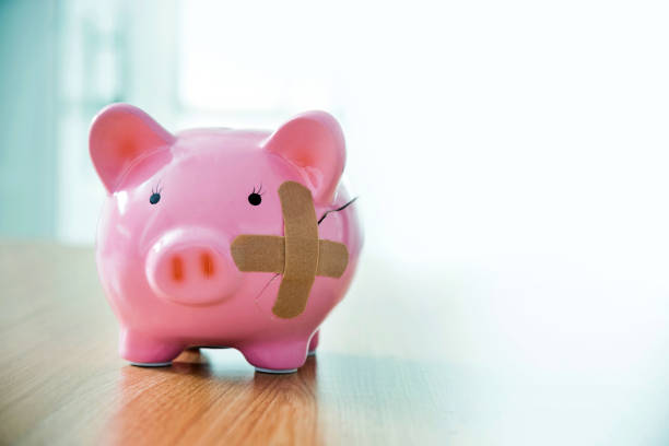 istock Broken piggy bank with adhesive bandage on the table 1391640656