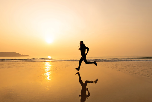 Man running on the golden beach.