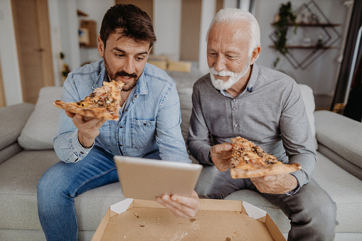 Father and son eating pizza together
