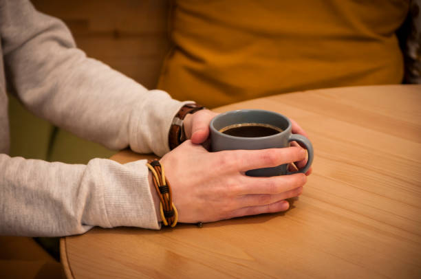istock mans hand holding a cup of coffee, close up 1391649711