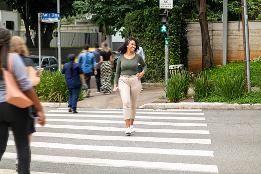 Photo of a woman crossing Faria Lima Avenue in Sao Paulo city.
