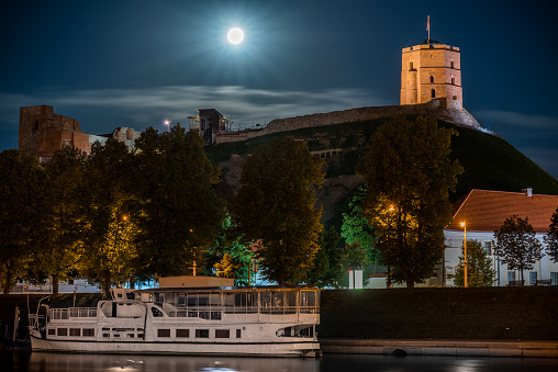 Gediminas Castle in Vilnius, Lithuania. Full Moon in Background. Night Photo, Long Exposure.