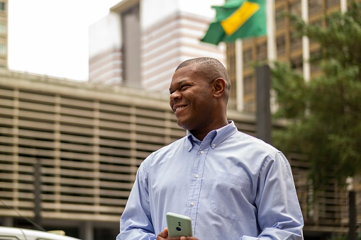 Photo of a man using smart phone at Paulista Avenue, Sao Paulo, Brazil.