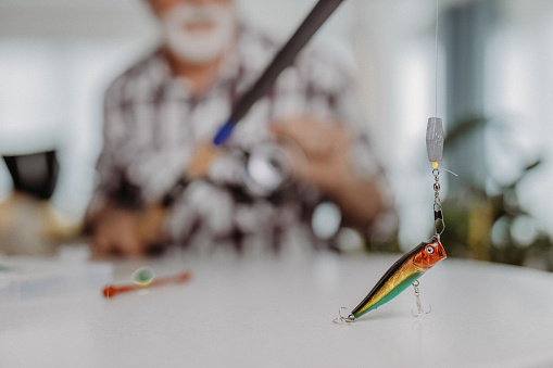 Senior man preparing for his fishing trip in the living room