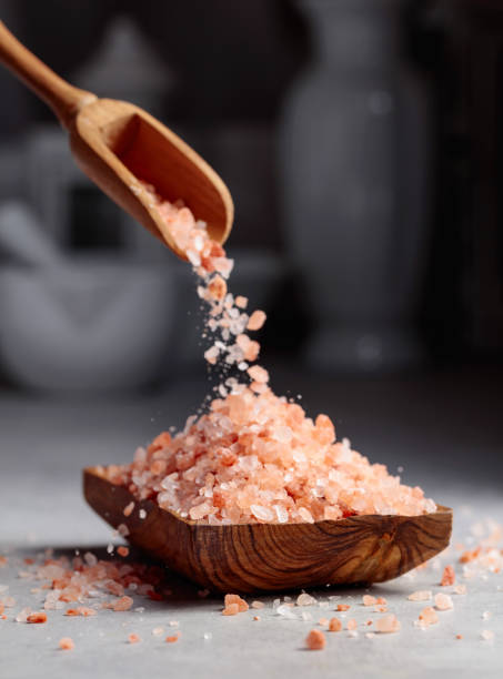 istock Pink salt is poured into a small wooden bowl. 1391657481