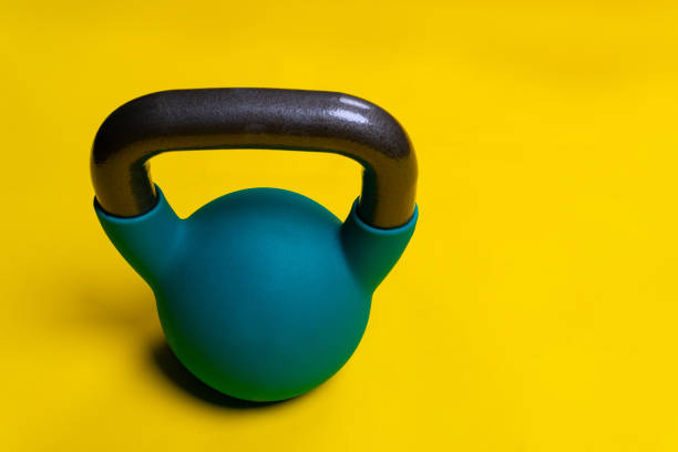 istock For Kettlebell yellow background Blue with space on a text space iron, for cast lifting in equipment from heavy lifestyle, kettle simple. Vivid pound shape, medical retro athletic strong 1391659425