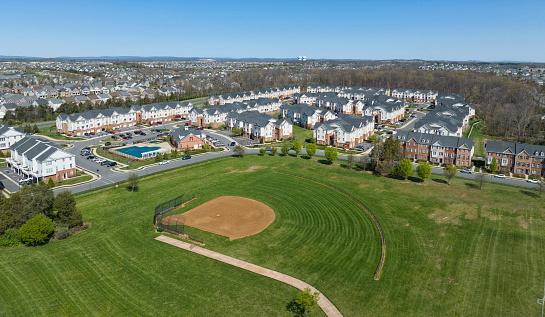 Aerial view of a baseball diamond with town homes in view.