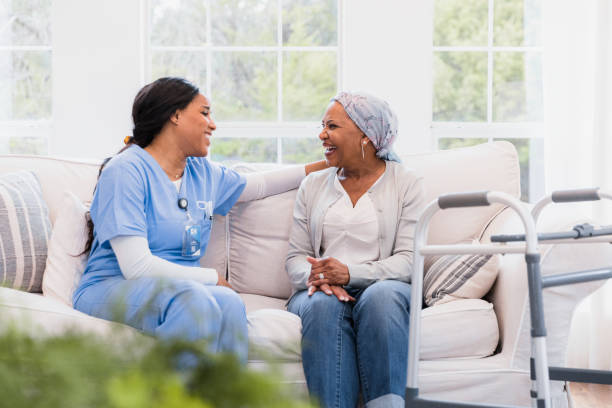 Hospice nurse sits and talks with her cancer patient The hospice nurse sits and talks with her cancer patient to make a bond. hospice photos stock pictures, royalty-free photos & images