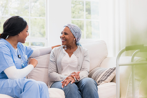 The elderly woman enjoys the conversation she is having with her hospice nurse.