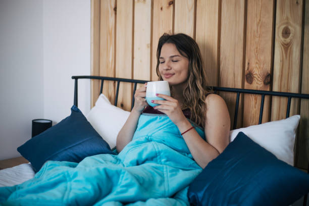 istock Beautiful young woman drinking coffee in bed. 1391665008