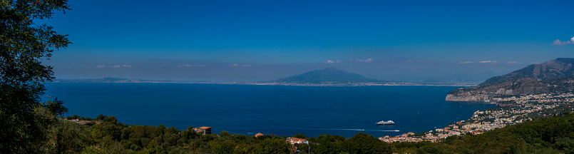 A panoramic image of the Gulf of Naples, taken from a hilltop on the Sorrento peninsula, showing the city of Sorrento and Mount Vesuvius across the gulf.