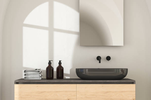 istock Close up of black sink with square mirror standing in on white wall 1391669254